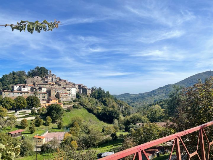 A stone village on a green hillside under a late-summer sky